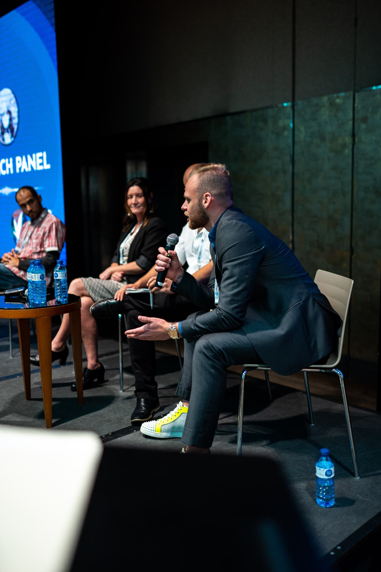Andreas Vezonik in a panel discussion holding a microphone